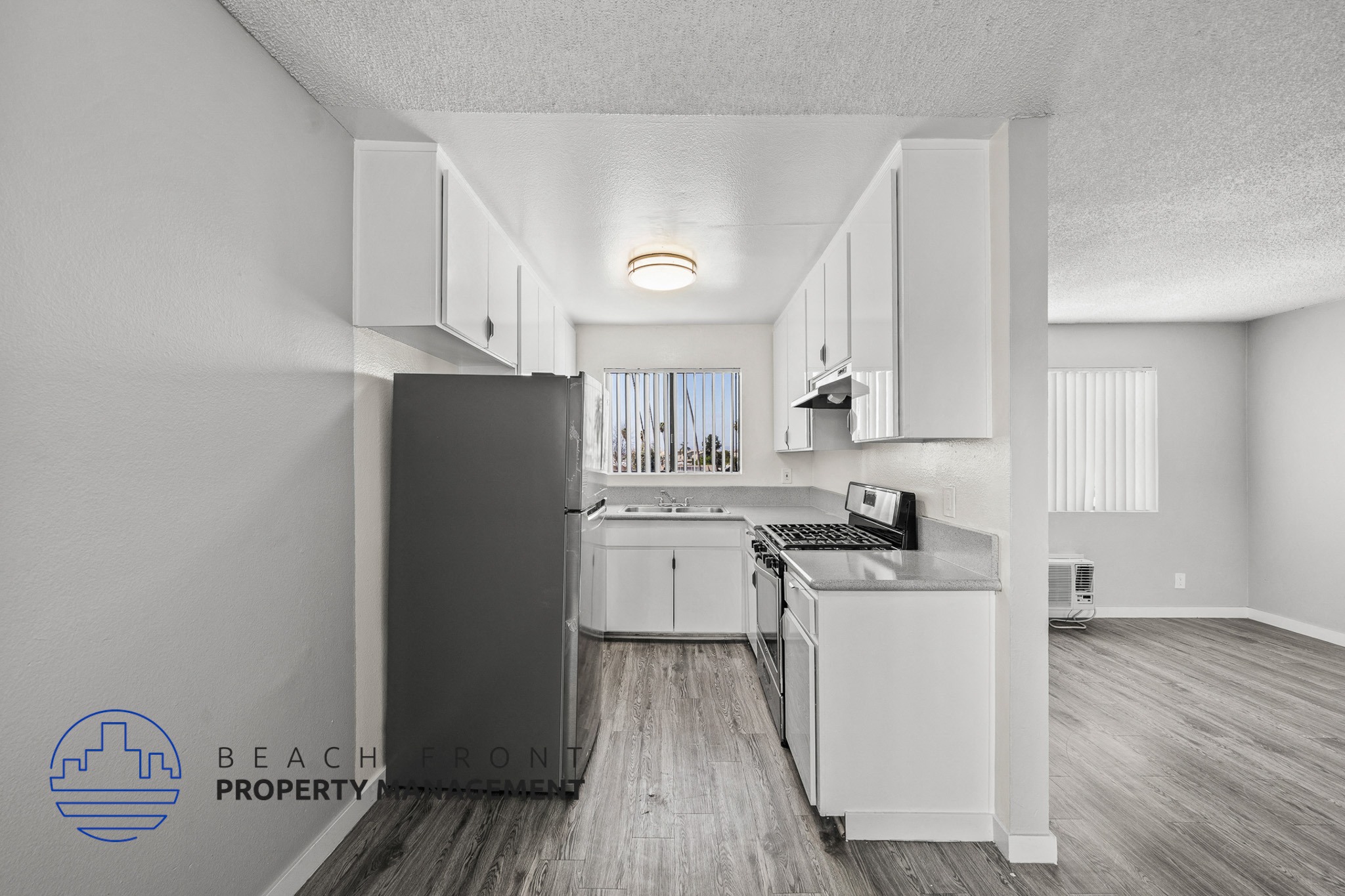 A kitchen with white cabinets and a refrigerator in a property.